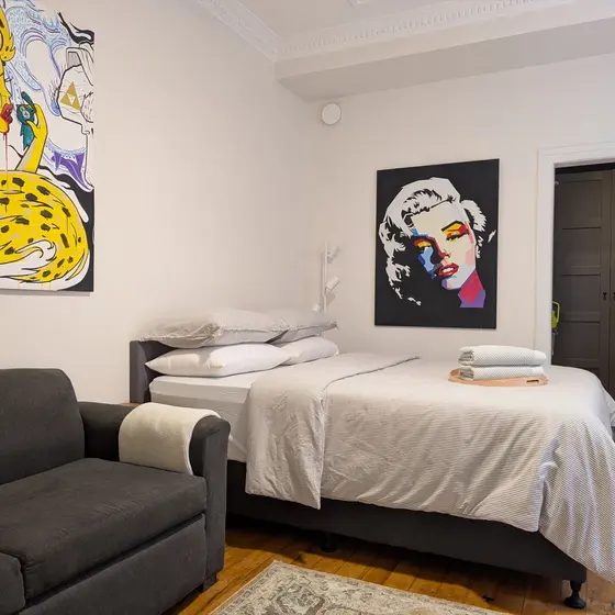 Queen bed with pop-art portraits at Laneway Studio, Surry Hills